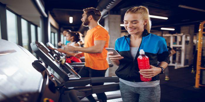 Ragazza in palestra cin smartphone